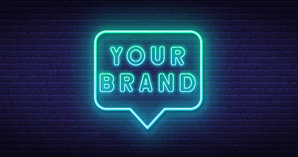 Luce neon blu "your brand" su sfondo scuro di mattoni